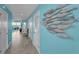 Hallway featuring tiled floors, blue walls decorated with fish ornaments, and access to the living areas at 19519 Gulf Blvd # 203, Indian Shores, FL 33785