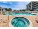 Relaxing hot tub next to the pool, offering a luxurious spa-like experience in a pristine outdoor setting at 19519 Gulf Blvd # 203, Indian Shores, FL 33785