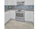 Close-up view of the kitchen featuring stainless steel appliances and tile flooring at 19519 Gulf Blvd # 203, Indian Shores, FL 33785