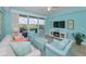 Living room with stylish coastal decor, a flat-screen TV, and sliding doors to a balcony with views at 19519 Gulf Blvd # 203, Indian Shores, FL 33785