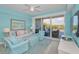 Living room with a ceiling fan, comfortable seating, and large sliding glass doors to a balcony at 19519 Gulf Blvd # 203, Indian Shores, FL 33785