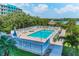 Community pool featuring lounge chairs, and a hot tub, all surrounded by lush landscaping with water views at 19519 Gulf Blvd # 203, Indian Shores, FL 33785