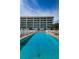 Community pool with a jacuzzi and plenty of lounge seating for residents and guests at 19519 Gulf Blvd # 203, Indian Shores, FL 33785