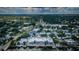 An aerial view shows a neighborhood's streetscape with houses, lawns, and tree lined streets with a waterway at 2186 Edythe Dr # 11, Dunedin, FL 34698