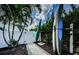 Backyard featuring a paved walkway, tropical foliage, and stand-up paddleboards at 2186 Edythe Dr # 11, Dunedin, FL 34698