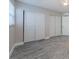 Bedroom with wood-look tile flooring, neutral paint, and closet with bi-fold doors at 2186 Edythe Dr # 11, Dunedin, FL 34698