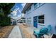Charming home exterior featuring a blue door, patio seating, and well-maintained landscaping at 2186 Edythe Dr # 11, Dunedin, FL 34698