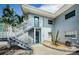Exterior of a two-story home with painted staircase, desert landscaping and turquoise painted doors at 2186 Edythe Dr # 11, Dunedin, FL 34698