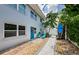 Charming exterior with a blue door, blue chairs, and lush tropical landscaping at 2186 Edythe Dr # 11, Dunedin, FL 34698