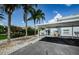 Two-story home with covered parking, a staircase, a blue door, cactus and palm trees at 2186 Edythe Dr # 11, Dunedin, FL 34698