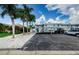 Exterior showing a two-story building, parking lot, tropical trees and rock landscaping at 2186 Edythe Dr # 11, Dunedin, FL 34698