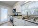 Updated kitchen with stainless steel appliances, granite countertops, and a door to the exterior at 2186 Edythe Dr # 11, Dunedin, FL 34698