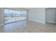 Open-concept living room features neutral paint, tile flooring, and sliding glass doors to the lanai at 2186 Edythe Dr # 11, Dunedin, FL 34698