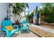Charming patio area with Adirondack chairs, tropical landscaping, and privacy fence at 2186 Edythe Dr # 11, Dunedin, FL 34698