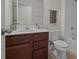 Well-lit bathroom with a single sink vanity, a bathtub with tiled walls, and contemporary finishes at 2432 Hearth Dr, Odessa, FL 33556