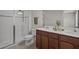 Elegant bathroom featuring a double sink vanity, a glass-enclosed shower, and modern fixtures at 2432 Hearth Dr, Odessa, FL 33556