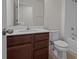 Bathroom featuring wood vanity, stone countertop, toilet, and shower-tub combo at 2432 Hearth Dr, Odessa, FL 33556