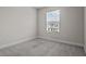 Neutral bedroom showcasing a gray carpet and a window view of a house outside at 2432 Hearth Dr, Odessa, FL 33556