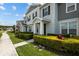 Inviting townhome featuring a manicured lawn and lush, green shrubbery at 2432 Hearth Dr, Odessa, FL 33556