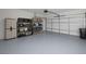 Spacious garage featuring epoxy flooring, storage shelves, and ample room for parking and organization at 2432 Hearth Dr, Odessa, FL 33556