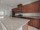 Close-up view of kitchen island with granite countertops and stainless steel appliances at 2432 Hearth Dr, Odessa, FL 33556
