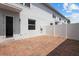 Brick patio area with white fence and partial view of exterior of home with siding at 2432 Hearth Dr, Odessa, FL 33556
