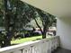 Balcony view showcasing tree-lined landscaping and a glimpse of nearby buildings, offering a tranquil outdoor space at 2630 Pearce Dr # 208, Clearwater, FL 33764