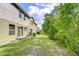 A view of the backyard, with ample green space and lush trees, extending from the back of the home at 2746 Birchcreek Dr, Wesley Chapel, FL 33544