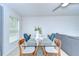 Bright dining area with modern glass table and stylish blue upholstered chairs at 2746 Birchcreek Dr, Wesley Chapel, FL 33544