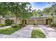 Inviting townhome exterior with attached garages, mature landscaping, and a well-manicured lawn at 2746 Birchcreek Dr, Wesley Chapel, FL 33544