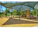Shaded playground area featuring swings, slides, and play equipment for children at 2746 Birchcreek Dr, Wesley Chapel, FL 33544