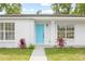 Close up of the home's entry, featuring a bright blue front door and manicured landscaping at 2901 Forestwood Dr, Seffner, FL 33584