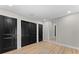 This bedroom features black closet doors, wood floors, and a light grey paint color at 3215 E Powhatan Ave, Tampa, FL 33610