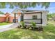 Lovely front yard view of a renovated home with modern colors, manicured landscaping, and inviting porch at 3215 E Powhatan Ave, Tampa, FL 33610