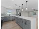 Modern kitchen boasts stainless steel appliances, quartz counters, gray and white cabinets, and an island at 3215 E Powhatan Ave, Tampa, FL 33610