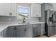 Updated kitchen featuring gray cabinets, stainless steel appliances, quartz countertops, and modern finishes at 3215 E Powhatan Ave, Tampa, FL 33610