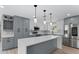 Modern kitchen boasts stainless steel appliances, quartz counters, gray and white cabinets, and a large island at 3215 E Powhatan Ave, Tampa, FL 33610