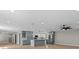 Open-concept kitchen with an island, stylish lighting, stainless steel appliances, and ample cabinet space at 3215 E Powhatan Ave, Tampa, FL 33610