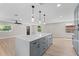 Spacious open-concept kitchen features gray cabinets, stainless appliances, and a large center island at 3215 E Powhatan Ave, Tampa, FL 33610