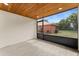Screened-in porch with a wood ceiling and light grey tile flooring, with a view of the yard at 3215 E Powhatan Ave, Tampa, FL 33610