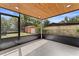 Porch featuring tiled floors and wood ceilings with view of backyard and exterior storage unit at 3215 E Powhatan Ave, Tampa, FL 33610