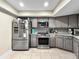 Modern kitchen featuring gray cabinets, stainless steel appliances, and ample counter space at 3508 Yale Cir, Riverview, FL 33578