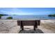 Beautiful beachfront view with sandy shores and a tranquil wooden bench, perfect for relaxation at 37 W Boyer St, Tarpon Springs, FL 34689