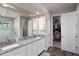 Bathroom with a double sink vanity, granite counters, and access to a walk-in closet at 3727 Wild Blossom Pl, Parrish, FL 34219