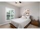 Bedroom featuring a queen-sized bed with neutral bedding, plantation shutters, and a decorative painting at 3727 Wild Blossom Pl, Parrish, FL 34219