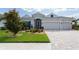 Beautiful single-story home with a three-car garage, paver driveway, manicured lawn, and mature trees at 3727 Wild Blossom Pl, Parrish, FL 34219