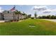 Expansive front yard featuring lush green grass, palm trees and shrubs, and a home exterior in the background at 3727 Wild Blossom Pl, Parrish, FL 34219