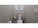 Small powder room with a white toilet, floral decoration and toilet paper storage at 3727 Wild Blossom Pl, Parrish, FL 34219