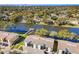 Aerial view showcases waterfront condo buildings surrounded by mature trees and a tranquil lake at 3823 N Oak Dr # K22, Tampa, FL 33611