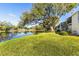 Lush green lawn leading to a tranquil lake, complemented by mature trees and condo building at 3823 N Oak Dr # K22, Tampa, FL 33611